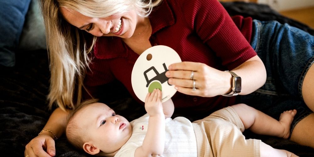 Mama zeigt Baby eine Kontrastkarte