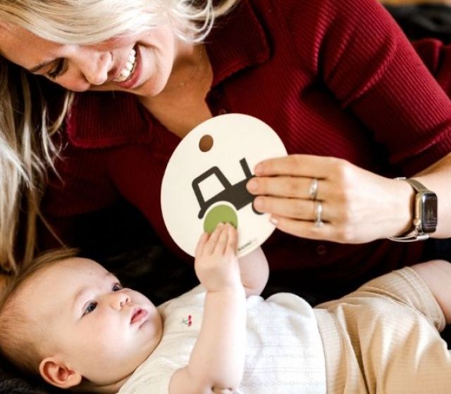 Mama zeigt Baby eine Kontrastkarte