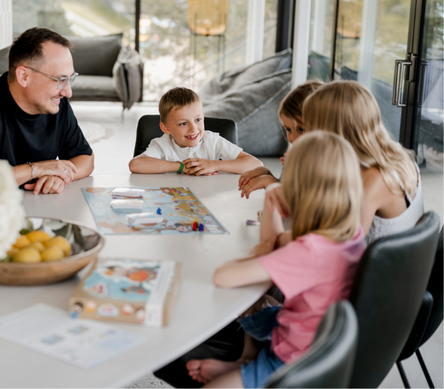 Familie spielt Achterbahn der Gefühle am Tisch
