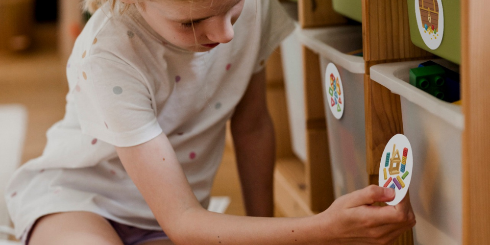 Kind beschriften Schubladen mit Ordnungsstickern