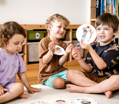 Kinder schauen sich gemeinsam Gefühlskarten an und zeigen, wie es ihnen geht