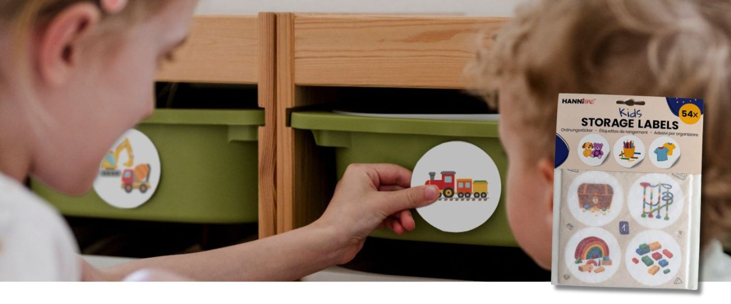 Kinder kleben Ordnungssticker auf Schubladen