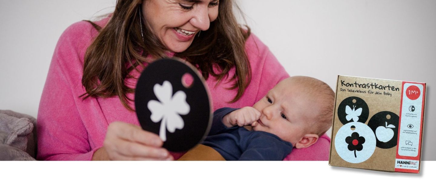 Oma zeigt einem Baby eine Kontrastkarte