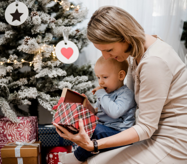 Mama mit Kind vor dem Weihnachtsbaum Weihnachtsgeschenke